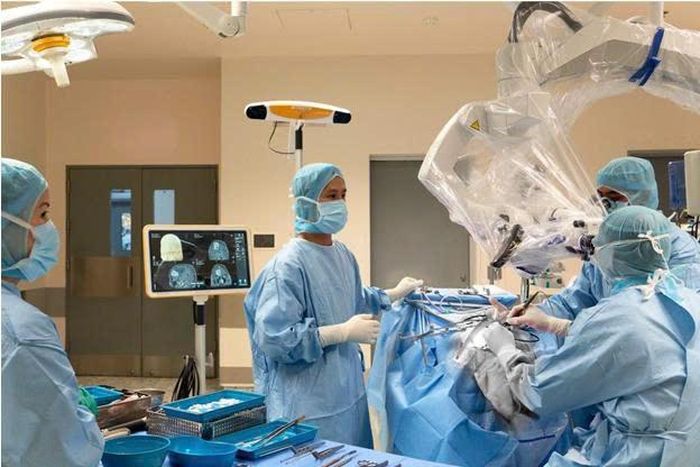 BS Lương Anh và ê-kíp phẫu thuật lấy máu tụ khỏi não bệnh nhân với sự hỗ trợ của hệ thống định vị thần kinh (Brain Navigation).