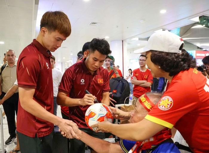 Cầu thủ ĐT Việt Nam về nước, ký tặng CĐV tại Sân bay Nội Bài sau trận thắng Indonesia với tỉ số 3-0. (Ảnh: VFF)
