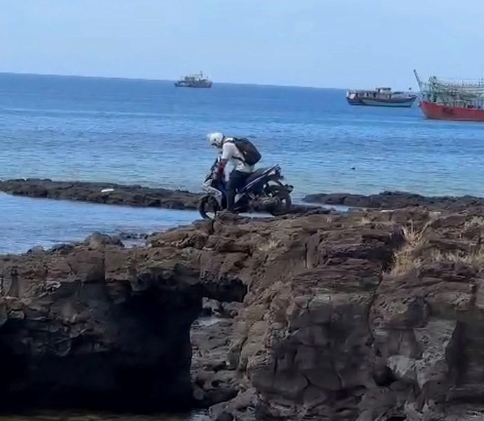 Hình ảnh du khách chạy xe máy lên vòm đá Cổng Tò Vò, khu vực đã lắp đặt biển cảnh báo cấm tác động lên di tích. Ảnh cắt từ clip người dân ghi lại