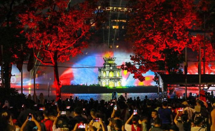 Màn trình diễn ánh sáng 3D Mapping trên Tháp Rùa kết hợp hệ thống màn nước thu hút sự quan tâm của đông đảo công chúng dịp kỷ niệm 80 năm Cách mạng tháng Tám và Quốc khánh 2/9. Ảnh: TTXVN