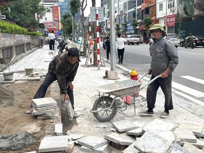 Công nhân nhà thầu tiến hành hoàn thiện phần nát vỉa hè trên đường Nguyễn Tuân (phường Thanh Xuân, thành phố Hà Nội. Ảnh: Quốc Lũy - TTXVN