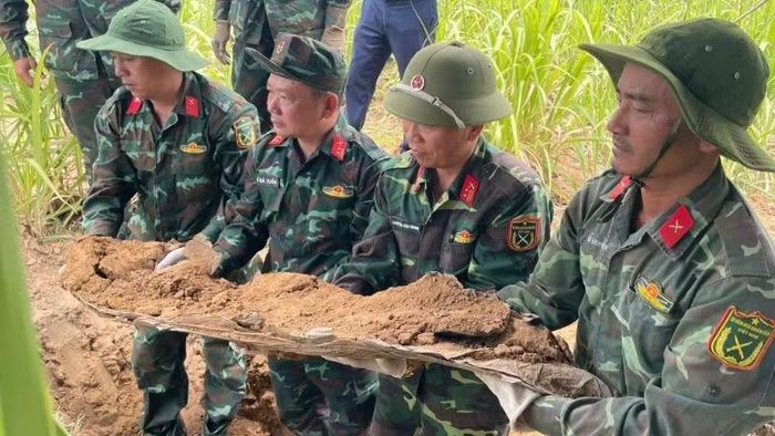 Cán bộ, chiến sĩ Đội K51 cất bốc hài cốt liệt sĩ lên mặt đất. (Ảnh: Quốc Khánh)