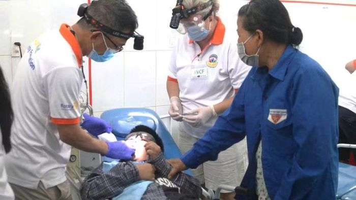 Các nha sĩ khám và điều trị răng miệng miễn phí cho học sinh (Ảnh: Hoàng Phúc)