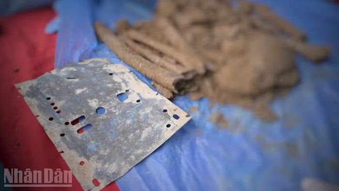 Một di vật mang thông tin cá nhân bên cạnh hài cốt liệt sĩ. (Ảnh: PHƯƠNG VŨ)