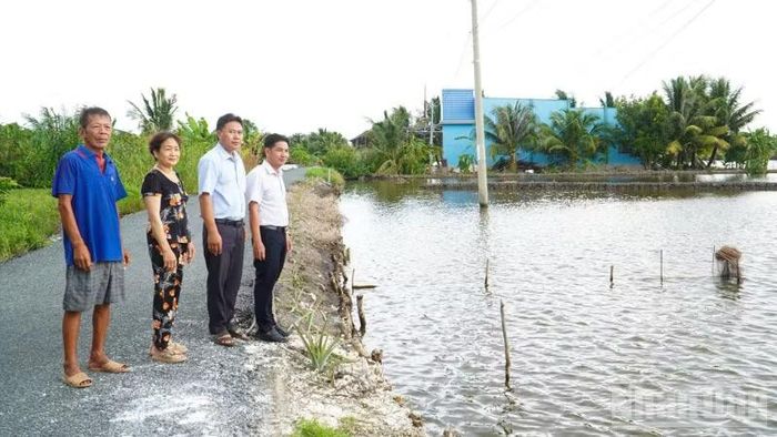 Cán bộ xã Lương Tâm và người dân đi thăm cánh đồng nuôi tôm. (Ảnh: Văn Út)