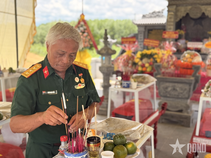 Cựu chiến binh Trần Ngọc Hiền bên các hài cốt đồng đội vừa quy tập được. Ảnh: VINH THY