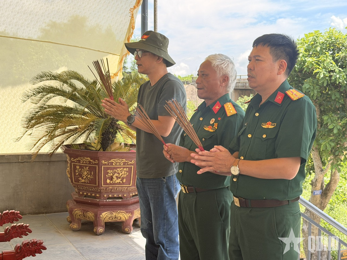 Cựu chiến binh Trần Ngọc Hiền và phóng viên Báo Quân đội nhân dân thắp hương tại đền thờ liệt sĩ. Ảnh: VINH THY