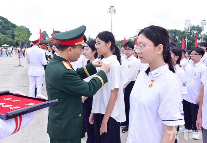 Đại tá Đỗ Hoàng Việt, Phó chính ủy Bộ tư lệnh Lăng Chủ tịch Hồ Chí Minh gắn Huy hiệu Bác Hồ tặng các học sinh.