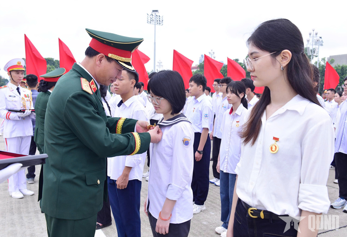 Thiếu tướng Trần Công Trường, Phó cục trưởng Cục Quân y, Tổng cục Hậu cần - Kỹ thuật gắn Huy hiệu Bác Hồ tặng các học sinh.