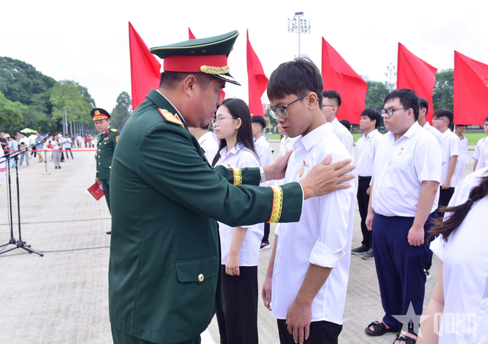 Thiếu tướng Huỳnh Tấn Hùng gắn Huy hiệu Bác Hồ tặng các học sinh.