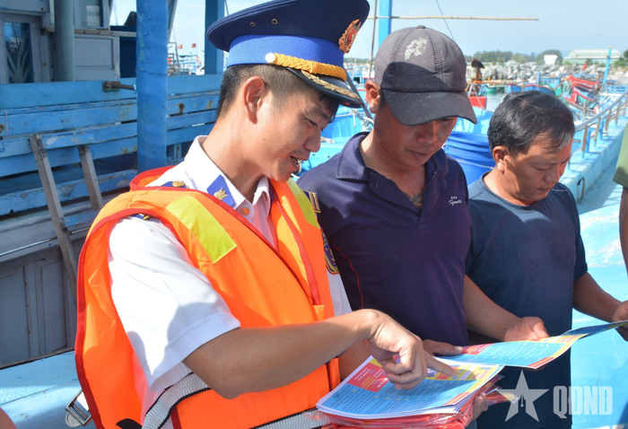 Cán bộ Vùng Cảnh sát biển 3 hướng dẫn ngư dân các nội dung tuyên truyền trên tờ rơi. 