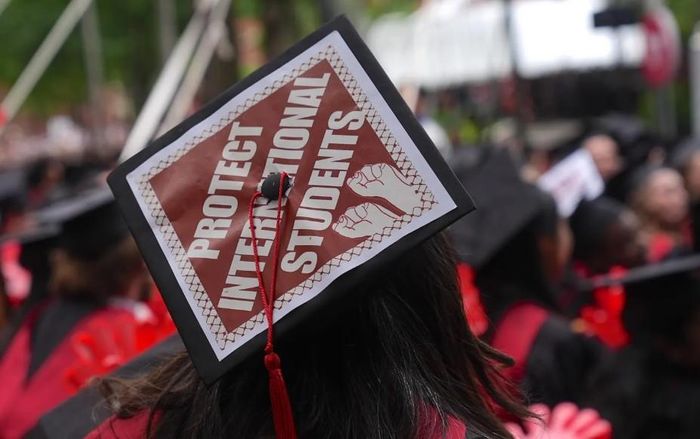 Trên nón của một sinh viên tốt nghiệp có dòng chữ Hãy bảo vệ sinh viên quốc tế. Ảnh: GETTY IMAGES