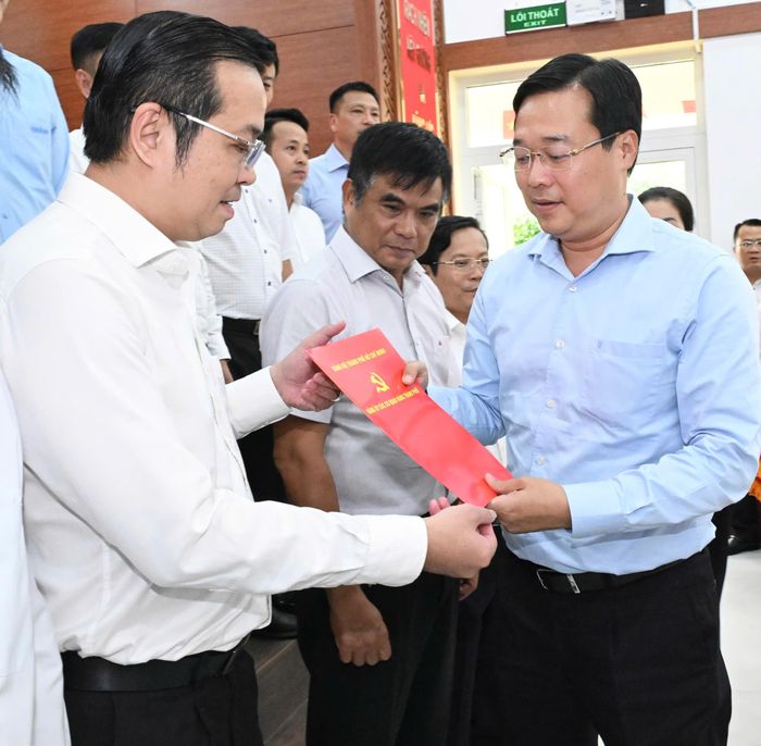 Phó Bí thư Thường trực Thành ủy TPHCM Lê Quốc Phong trao quyết định đến đồng chí Lê Văn Minh. Ảnh: VIỆT DŨNG 