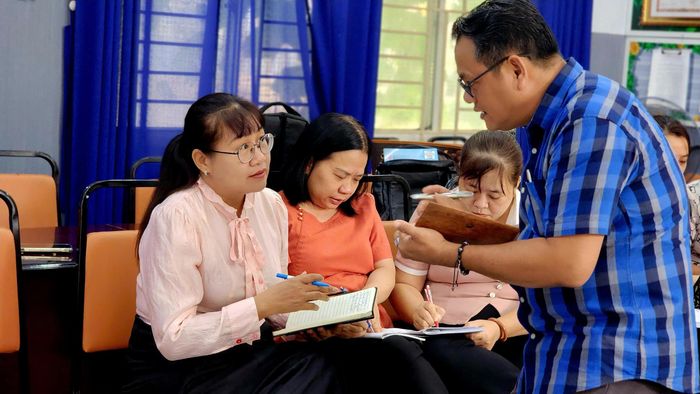 Cô Phạm Thúy Hà, Hiệu trưởng Trường Tiểu học Đặng Trần Côn (áo hồng bên trái) - tham gia bồi dưỡng kỹ năng giao tiếp tiếng Anh với giáo viên
