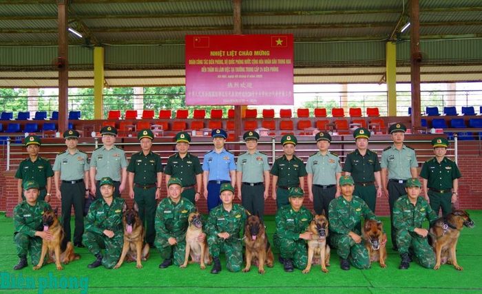 Đoàn công tác hai bên chụp hình lưu niệm cùng tập thể cán bộ thực hiện huấn luyện quân khuyển. Ảnh: Thủy Nguyên