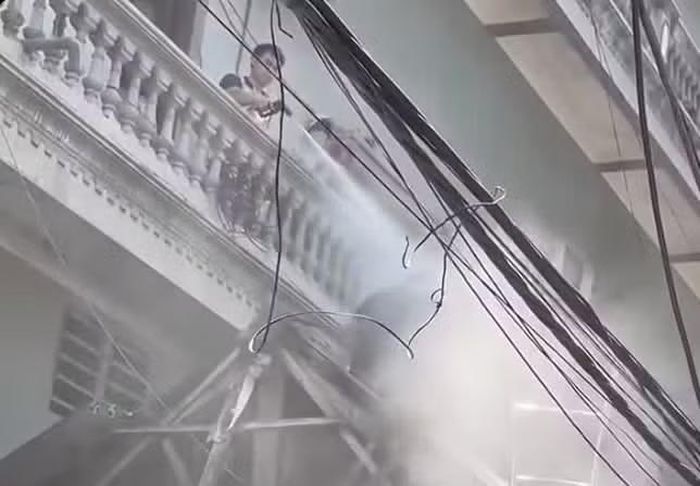 Mạnh dùng vòi xịt nước xịt vào người công nhân tháo dỡ mái nhà hàng xóm. Ảnh cắt từ video.