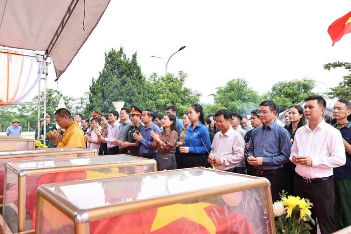 Lực lượng chức năng thực hiện nghi lễ truy điệu và an táng 8 hài cốt liệt sĩ chưa xác định danh tính.