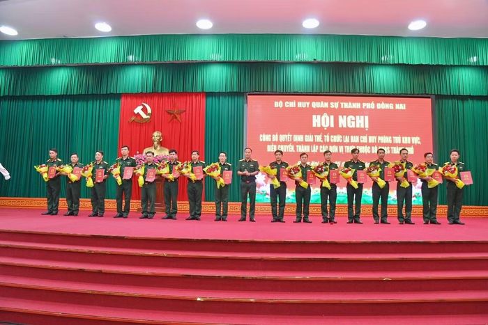 Đại tá Võ Thành Danh - Chỉ huy trưởng Bộ CHQS thành phố, trao quyết định, tặng hoa cho cán bộ Trung đoàn Bộ binh 41 (Ảnh: Văn Chung)