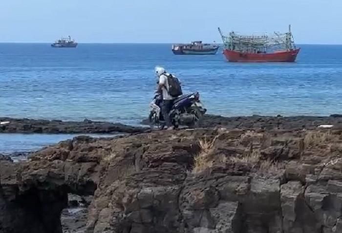 Du khách nước ngoài điều khiển xe máy lên cổng Tò Vò ở đặc khu Lý Sơn. Ảnh cắt từ clip