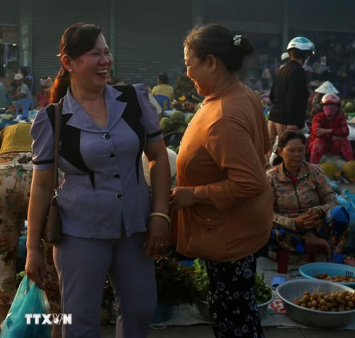 Đi chợ gặp nhau là trò chuyện vui vẻ giữa người mua và người bán. (Ảnh: Duy Khương/TTXVN)