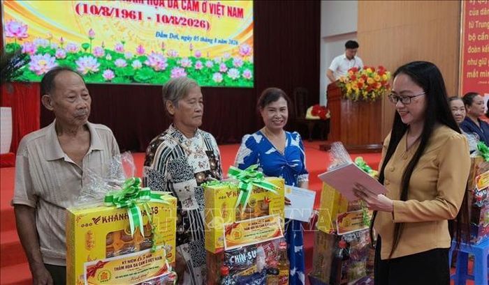 Phó Bí thư Thường trực Đảng ủy xã Đầm Dơi Lục Thùy Dương trao quà cho nạn nhân da cam tại buổi họp mặt. Ảnh: TTXVN phát