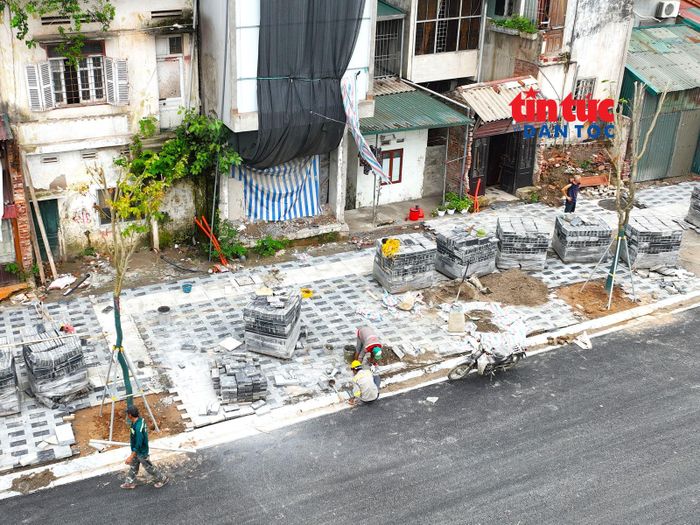 Các tốp công nhân thi công hạng mục vỉa hè, trồng cây xanh trên tuyến Vành đai 1 đoạn từ nút giao Voi Phục đến Bệnh viện Phụ sản Hà Nội.