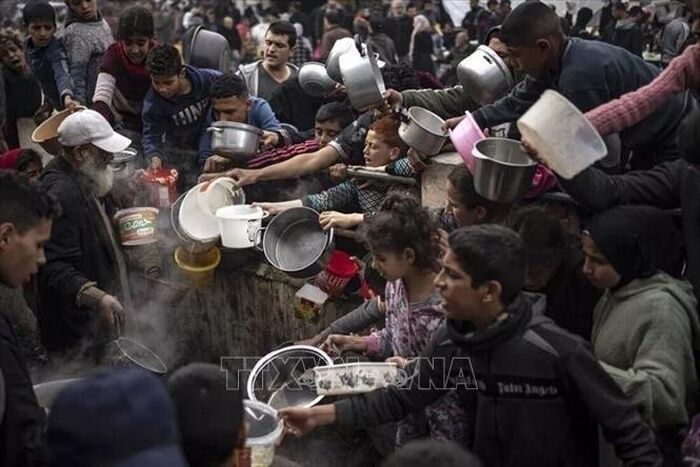 Người dân Palestine nhận thức ăn cứu trợ tại Dải Gaza. Ảnh: THX/TTXVN