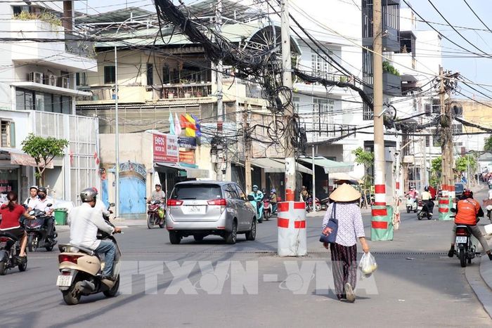 Nhiều trụ điện trên tuyến vẫn chưa được di dời, khiến dự án mở rộng đường Chu Văn An chưa thể hoàn thành, đồng thời ảnh hưởng đến an toàn giao thông và mỹ quan đô thị. Ảnh: Tiến Lực - TTXVN