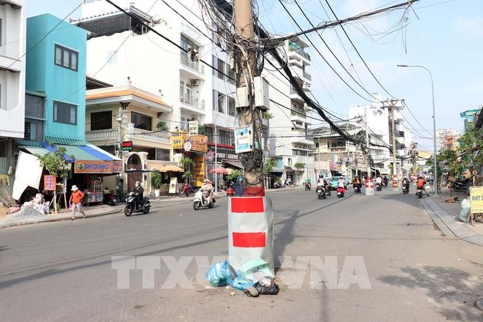 Nhiều trụ điện trở thành nơi tập kết rác thải, ảnh hưởng đến mỹ quan đô thị. Ảnh: Tiến Lực - TTXVN