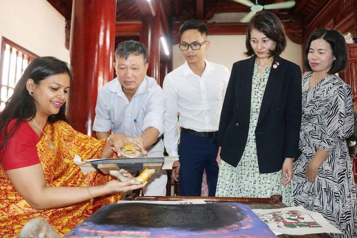 Du khách trải nghiệm làm tranh dân gian Đông Hồ. Ảnh: Trần Thảo.