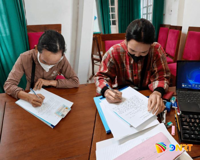 Hai phụ nữ viết tờ khai về việc buôn bán hàng rong tại bán đảo Sơn Trà. Ảnh: Công an phường Sơn Trà