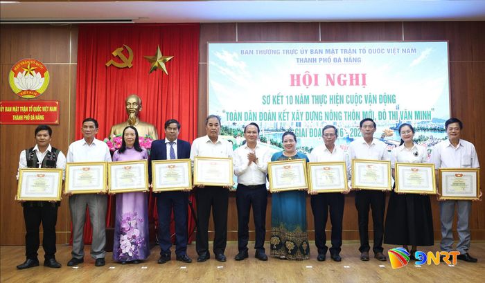 Phó Bí thư Thành ủy, Chủ tịch Ủy ban MTTQ Việt Nam thành phố Nguyễn Đình Vĩnh (giữa) trao bằng khen cho 10 tập thể có thành tích xuất sắc trong thực hiện cuộc vận động. Ảnh: NGỌC HÀ
