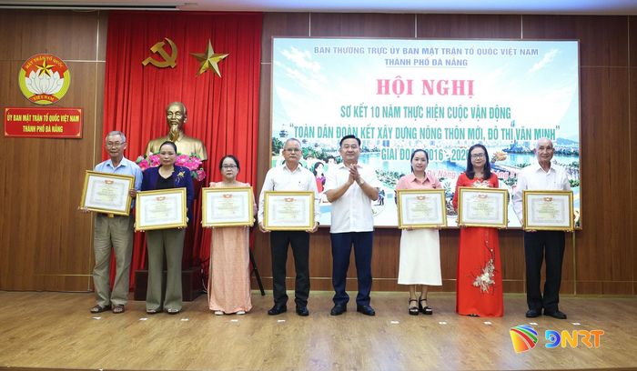 Phó Chủ tịch HĐND thành phố Nguyễn Công Thanh (thứ 4, từ phải sang) trao bằng khen cho 7 cá nhân có thành tích xuất sắc trong thực hiện cuộc vận động. Ảnh: NGỌC HÀ