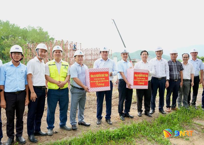 Phó Bí thư Thường trực Thành ủy Nguyễn Khắc Toàn (thứ 5, từ trái sang) tặng quà cho đơn vị thi công tại công trình tuyến đường kết nối đường vành đai phía Tây đến cao tốc La Sơn - Túy Loan. Ảnh: T.CÔNG