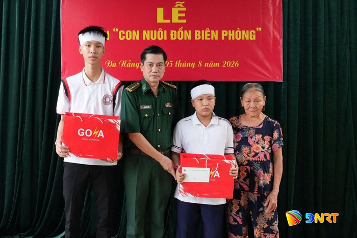 Đại tá Hoàng Văn Mẫn, Chính ủy Bộ đội Biên phòng thành phố tặng quà cho hai anh em Lê Viết Hồng Anh và Lê Viết Hồng Pháp. Ảnh: HUỲNH CHÍN