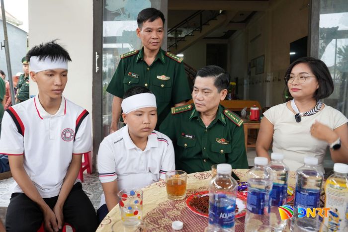Lãnh đạo Bộ đội Biên phòng thành phố cùng nhà hảo tâm động viên hai anh em Lê Viết Hồng Anh và Lê Viết Hồng Pháp. Ảnh: HUỲNH CHÍN