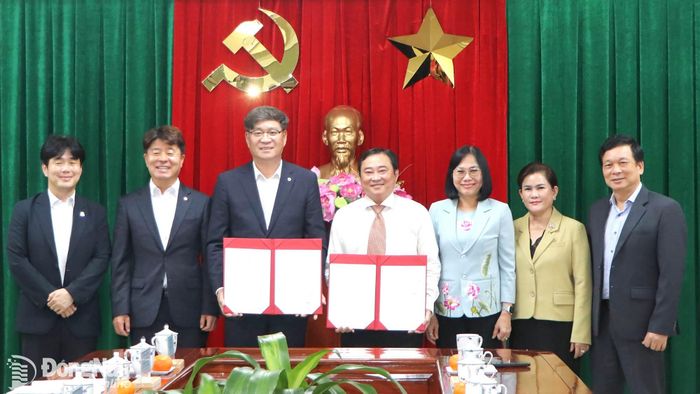  Thành ủy viên, Giám đốc Sở Nội vụ Nguyễn Hữu Định (giữa) và Quận trưởng quận Hamyang (thứ 3 từ trái qua) trao Bản ghi nhớ đã ký kết giữa 2 đơn vị. Ảnh: Ngọc Liên