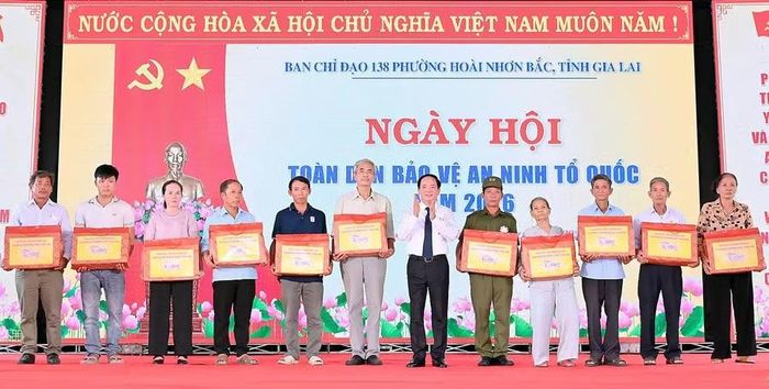 Đồng chí Trịnh Văn Quyết tặng quà cho 10 cá nhân thuộc gia đình chính sách và cá nhân có thành tích xuất sắc trong xây dựng phong trào toàn dân bảo vệ ANTQ trên địa bàn phường Hoài Nhơn Bắc. Ảnh: Đức Thụy