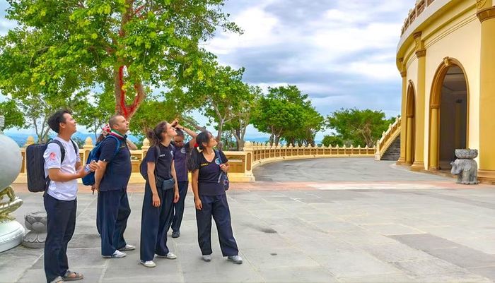  Tình nguyện viên giới thiệu về khu du lịch tâm linh thiền viện Thiên Hưng cho các võ sư, võ sinh quốc tế trong chuyến tham quan. Ảnh: Đoan Ngọc 