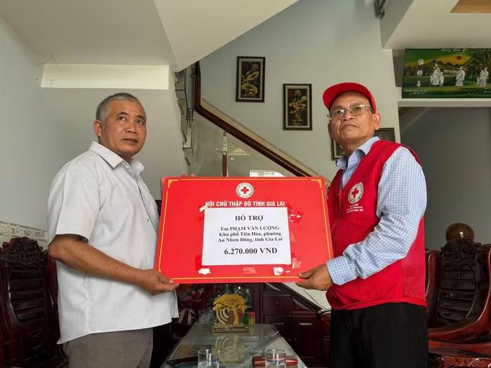 Ông Hà Văn Cát - Chủ tịch Hội Chữ thập đỏ Gia Lai trao tiền hỗ trợ đến gia đình anh Lượng. Ảnh: Quỳnh Ngân