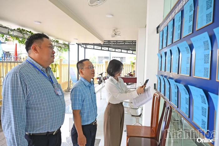 Thành viên đoàn kiểm tra kiểm tra việc niêm yết thủ tục hành chính và mã QR tại Trung tâm Phục vụ hành chính công phường.