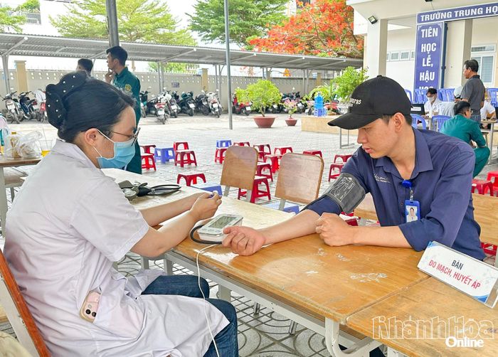 Cán bộ y tế đo huyết áp cho người dân.