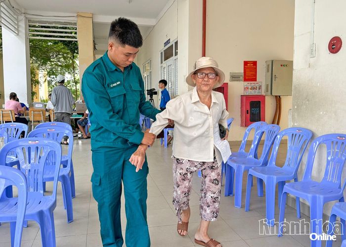 Người cao tuổi được hỗ trợ dìu vào nơi khám bệnh.