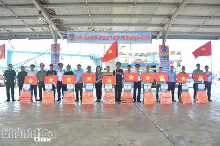 Ban tổ chức tặng cờ Tổ quốc và quà cho các gia đình ngư dân có hoàn cảnh khó khăn.