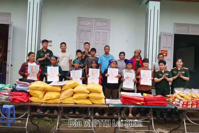 Đại diện Phòng Chính trị, Hội Phụ nữ, Đội Sản xuất và Xây dựng cơ sở chính trị số 1 (Đoàn Kinh tế - Quốc phòng 356) trao cờ Tổ quốc và ảnh Bác Hồ cho nhân dân bản Tỷ Phùng.