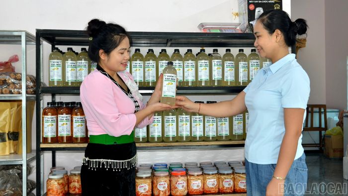 Chị Yêu (bên trái) giới thiệu sản phẩm dấm táo mèo của gia đình với khách hàng.