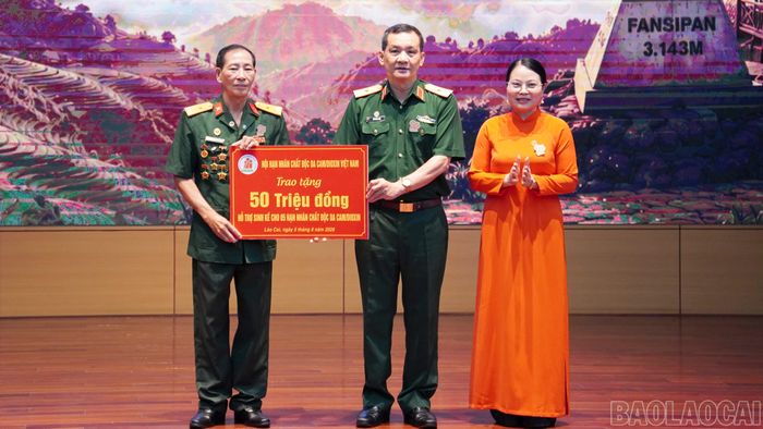 Thiếu tướng Đỗ Hồng Lâm - Phó Chủ tịch Trung ương Hội Nạn nhân chất độc da cam/dioxin Việt Nam trao biển tượng trưng hỗ trợ tiền cho Hội Nạn nhân chất độc da cam/ dioxin tỉnh Lào Cai.