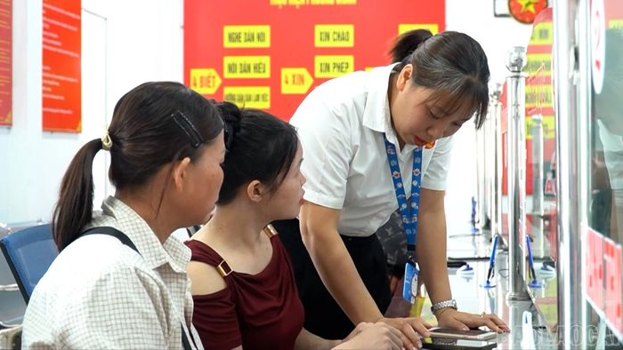 Chị Nghiêm Thị Linh hướng dẫn người dân cài đặt và sử dụng các ứng dụng số.