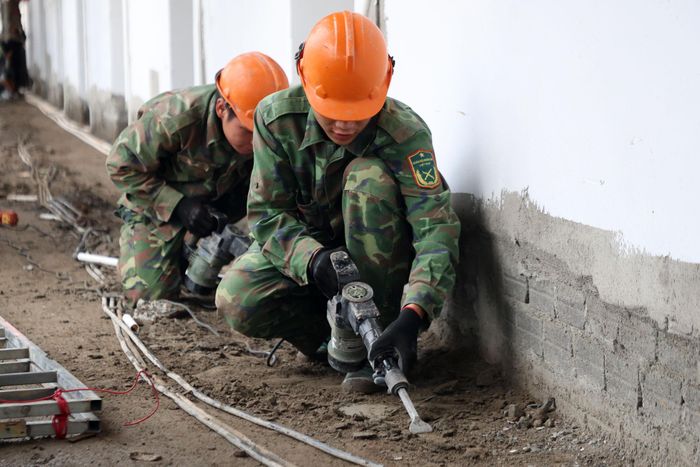 Chiến sĩ Tạ Văn Hiệp tham gia hỗ trợ lắp đặt điện tại khu nội trú