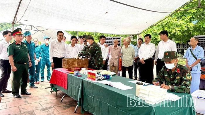 Cán bộ, đảng viên và thân nhân liệt sĩ theo dõi lực lượng chức năng lấy mẫu ADN các hài cốt liệt sĩ.